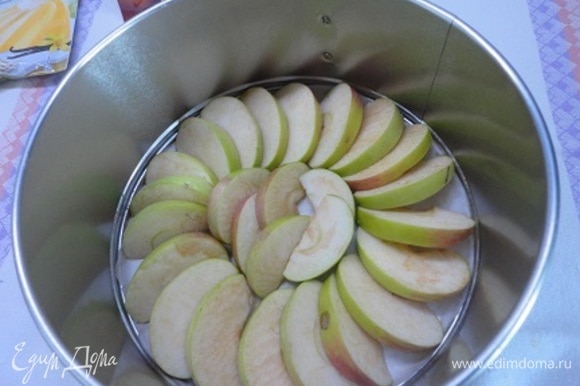 Подготовить форму диаметром 20–21 см: смазать дно и бока маслом. Яблоки (у меня указан чистый вес, без серединки) нарезать на дольки и уложить на дно. Духовку разогреть до 180°C.