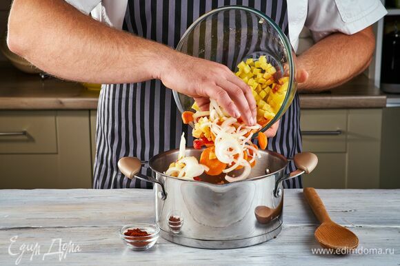 Обжарьте лук, морковь, картофель и помидор на растительном масле. Добавьте паприку и тушите 4 минуты, помешивая.