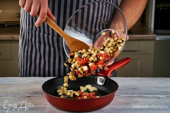 Налейте в сковороду оливковое масло и обжарьте в нем чеснок, добавьте баклажаны и помидоры. Тушите в течение 10 минут на среднем огне.