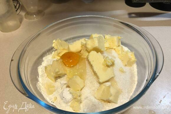 Муку смешать с сахаром, выложить порубленное кусочками масло, добавить соль, яйцо, замесить хорошо тесто.