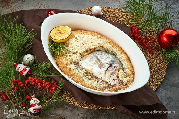 Запекайте рыбу в предварительно разогретой до 200°С духовке 20 минут. При помощи щипцов извлеките горячую рыбу и выложите на блюдо. Украсьте и подавайте к праздничному столу!