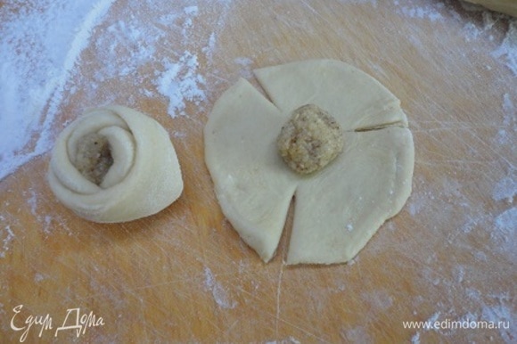 На кружочки из теста выложить начинку (примерно с грецкий орех), сделать три надреза и свернуть розочкой.