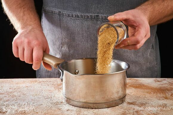 Приготовьте соус. В сотейник высыпьте сахар. Расплавьте сахар на небольшом огне, постоянно помешивая. Следите, чтобы он не подгорел.