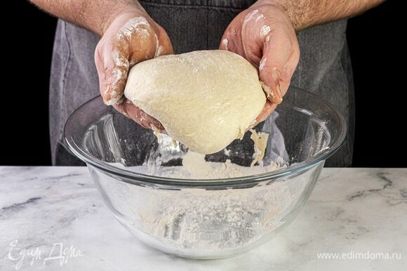 На припыленной мукой поверхности раскатайте подошедшее тесто в круг толщиной 3 мм, сформируйте небольшие бортики.