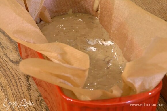 Форму для кекса выстелить бумагой для выпечки, выложить тесто и разровнять его.