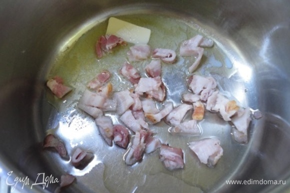 В кастрюле с толстым дном разогреть сливочное и растительное масло, добавить мелко нарезанный бекон.