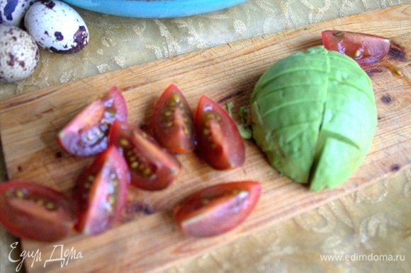 Нарезать авокадо и томаты сорта кумато.