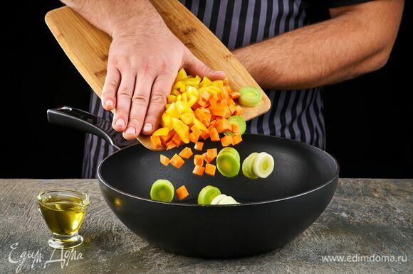 На сковороде в смеси растительного и сливочного масла слегка обжарьте лук-порей, морковь и болгарский перец.