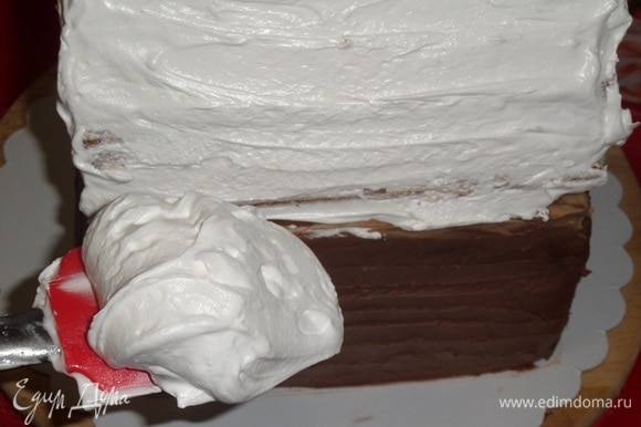 Лопаткой наносим белковый крем на крышу избушки со всех сторон.