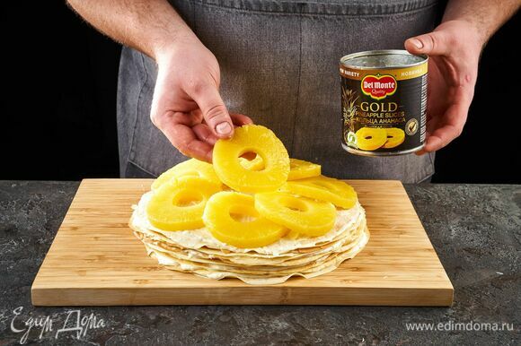 Самый верхний слой тоже смажьте кремом и выложите кольцами ананаса Del Monte Gold.