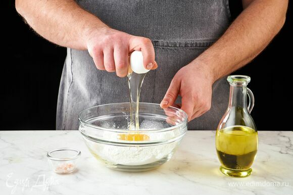 Приготовьте тесто для равиоли. В глубокой чаше соедините муку, яйцо, оливковое масло и соль.