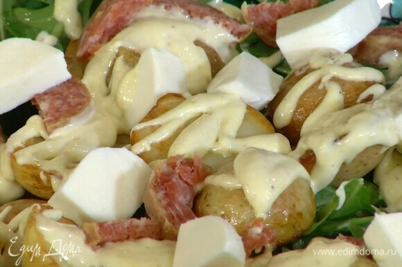 Оливки и обжаренный картофель выложить в салатник к руколе, полить майонезом, сверху разложить салями и моцареллу.
