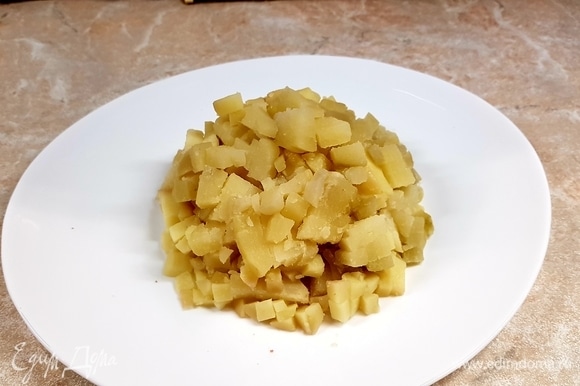 Картофель отварить и остудить. Нарезать кубиком и уложить на тарелку горкой.