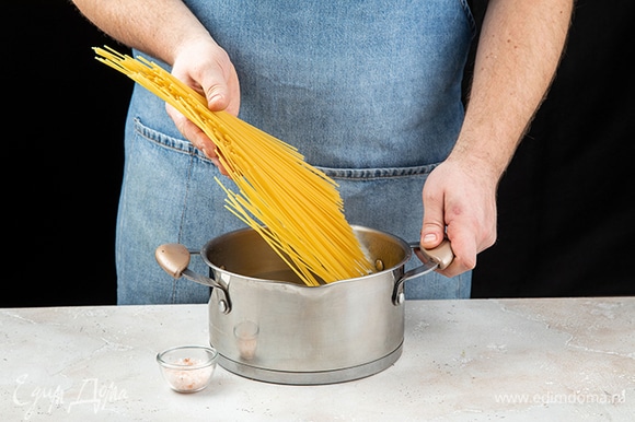 Отварите спагетти в подсоленной воде до состояния альденте. Воду слейте в отдельную емкость и сохраните. А спагетти верните в кастрюлю и накройте крышкой.