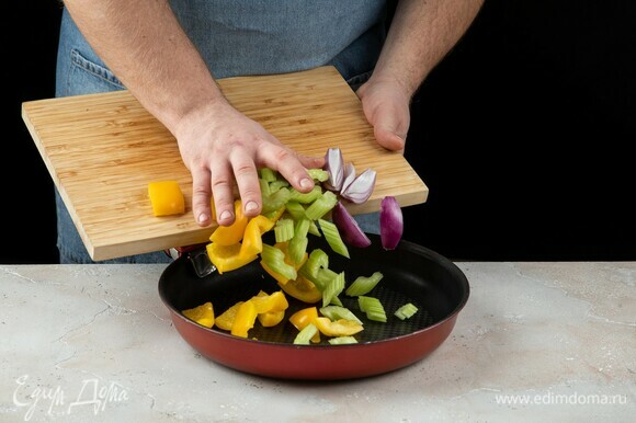 Перец, сельдерей и лук переложите в сковороду.