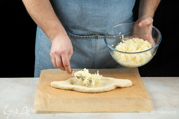 Тесто раскатайте, сформируйте лодочку, выложите сыр.