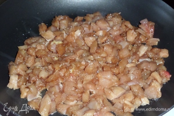 В разогретую сковороду наливаем 1 ст. л. растительного масла и выкладываем замаринованное куриное мясо.