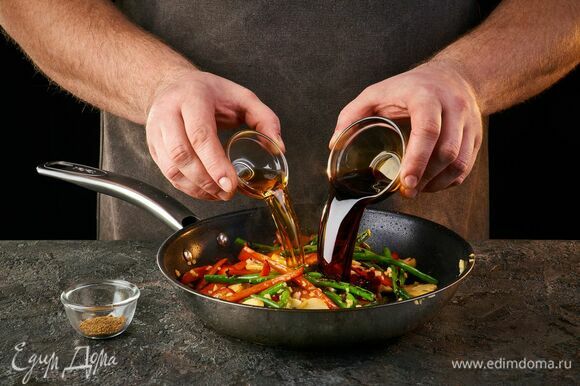 Влейте соевый и рыбный соусы к овощам. Перемешайте.