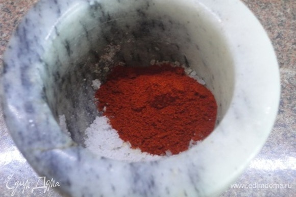 Готовим заправку — растираем чеснок с солью в ступке и смешиваем с красной сладкой паприкой.