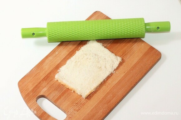 Берем 3 кусочка хлеба для тостов и отрезаем аккуратно корочку. Раскатываем кусочки хлеба скалкой.