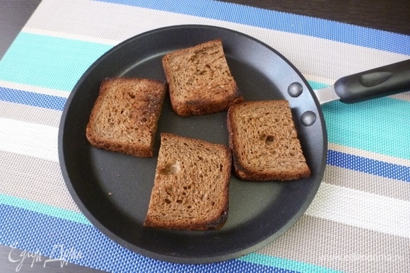 Ломтики бородинского или другого черного хлеба подсушить на сухой сковороде.