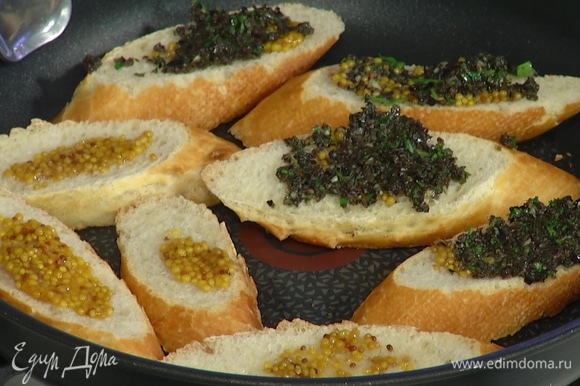 Разогреть большую сковороду и уложить хлеб маслом вниз, сверху смазать горчицей, выложить на каждый кусочек по 1 ч. ложке пасты из маслин.