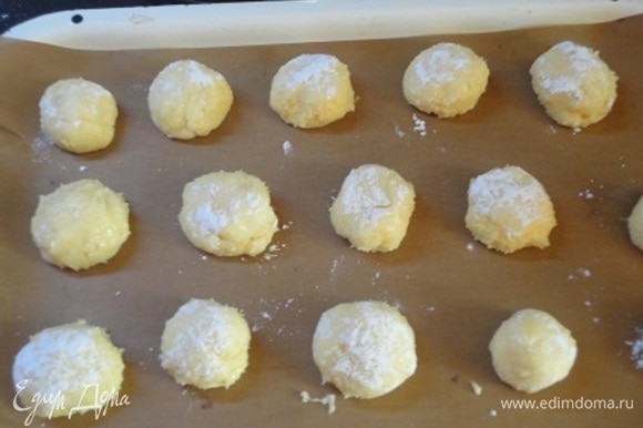 Отщипните от теста кусочек величиной с грецкий орех, скатайте в шарик и обваляйте в сахарной пудре. Выложите печенье на лист для выпечки, выкладывайте на достаточном расстоянии друг от друга. Выпекайте в духовке при температуре 180°C в течение 15 минут.