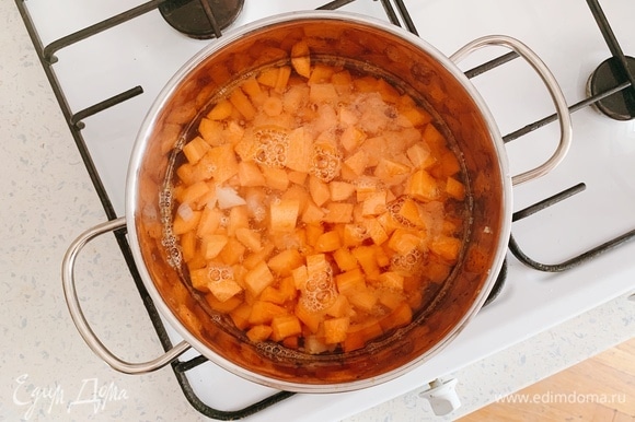 В кастрюлю добавьте обжарку из лука и чеснока и нарезанную морковь. Влейте столько воды, чтобы она покрывала овощи.