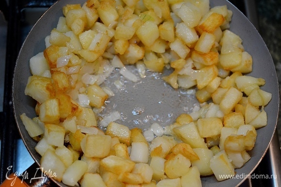 Перемешайте, отодвиньте к краям сковороды обжаренную картошку с луком.