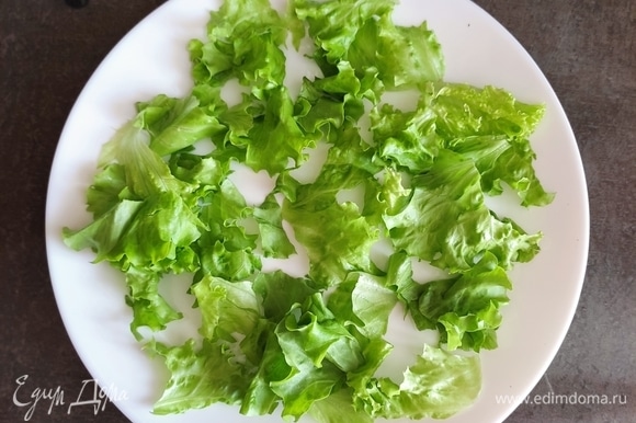 На большую тарелку рвем и выкладываем листья салата (предварительно вымыть, обсушить).