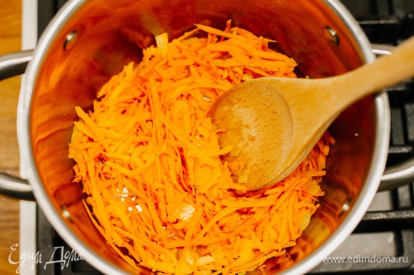 Как только лук станет мягким, добавить морковь, очищенную и измельченную на крупной терке. Обжарить еще 1–2 минуты.