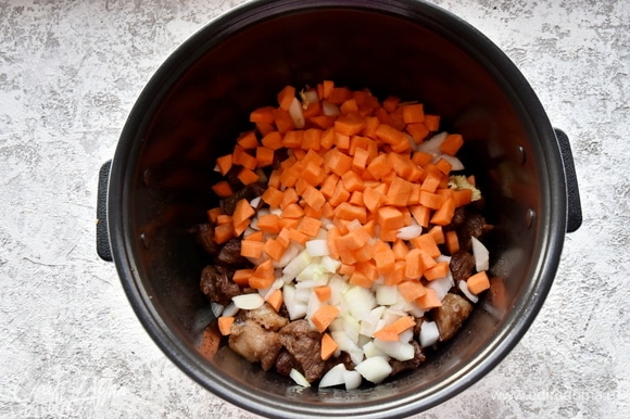 Перекладываю к мясу морковь и лук. Солю, перчу и перемешиваю.