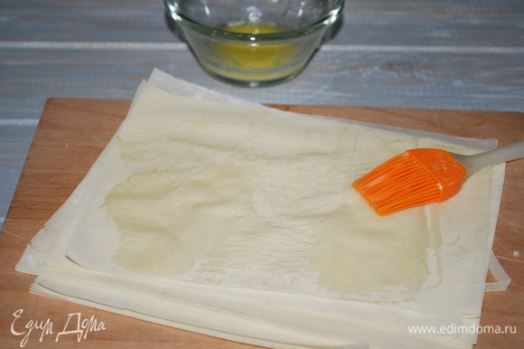 Тесто фило разрежьте на квадраты и, перед тем как выложить в форму, смажьте маслом.