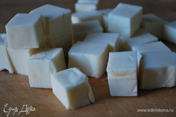 Сыр нарежьте на кубики и добавьте в суп. Прогрейте крем-суп вместе с сыром, пока он полностью не расплавится.