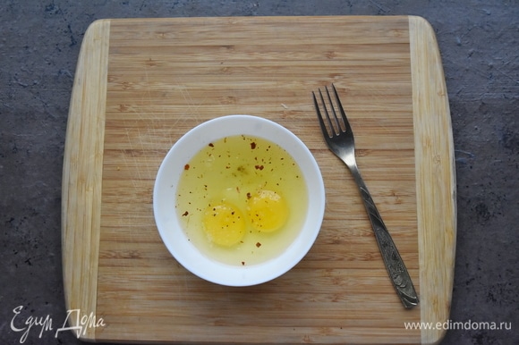 Два яйца размешиваю вилочкой в миске. Солю, добавляю щепотку хлопьев красного острого перца.