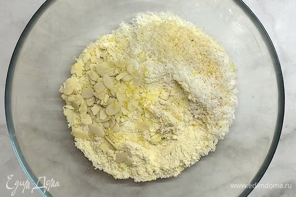 Смешиваем миндальную и кокосовую муку, миндальные лепестки (половину) и добавляем лимонную цедру.