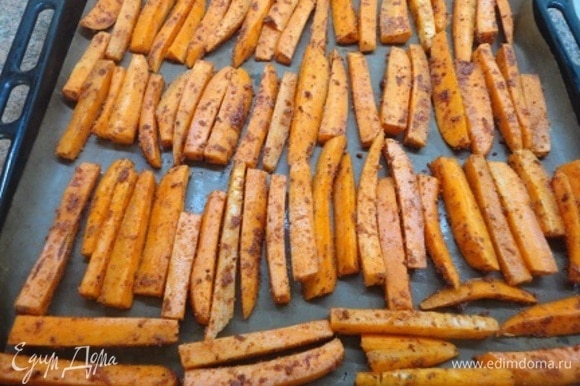 Выложите морковь в специях на противень в один слой и запекайте в центре духовки 15 минут.