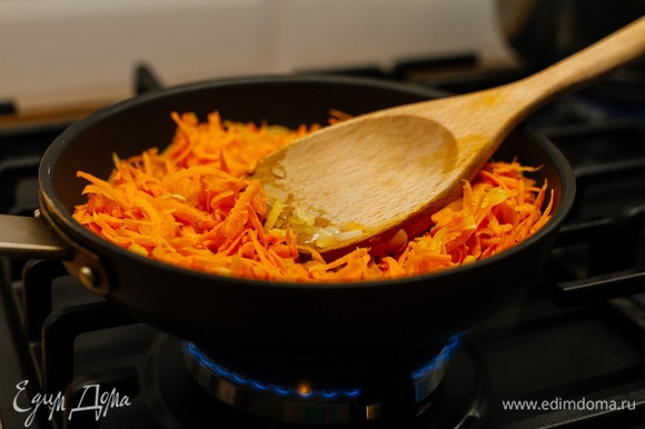 Добавить натертую на крупной терке морковь и обжаривать еще 2 минуты.
