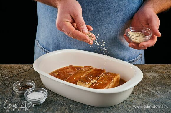 Переложите рыбу в форму для запекания, полейте соусом со сковороды, посолите и поперчите по вкусу. Посыпьте кунжутом. Запекайте при 200°C около 10 минут.