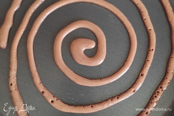 На хорошо разогретую сковороду быстро распределяем шоколадное тесто, начиная от центра по спирали.