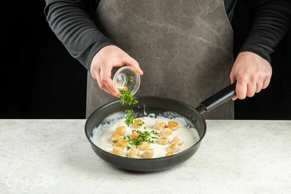 Верните гребешки в соус, добавьте рубленую петрушку, прогрейте в течение 1 минуты.