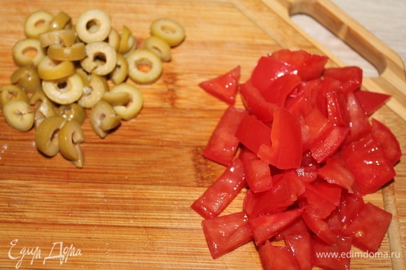 Нарезаем оливки и помидор.
