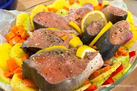 Вытащите форму из духовку и выложите поверх овощей рыбу. Посолите, поперчите и приправьте сушеным чесноком. Сбрызните лимоном (между рыбными стейками вы можете положить дольки лимона). Отправьте в духовку еще на 30 минут.