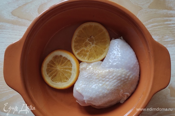 На дно формы для запекания выложить кусочки апельсина, который был в маринаде, сверху уложить куриные бедра.