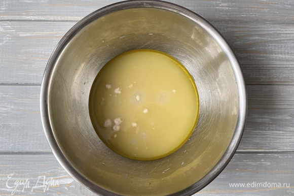 В большую миску налейте теплую воду, добавьте сахар, соль, свежие дрожжи и оливковое масло. Перемешайте ложкой до объединения.