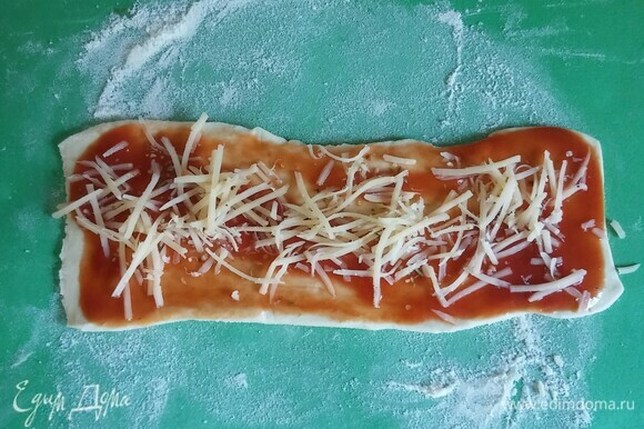 Посыпать прямоугольники тертым сыром и приправой для пиццы.