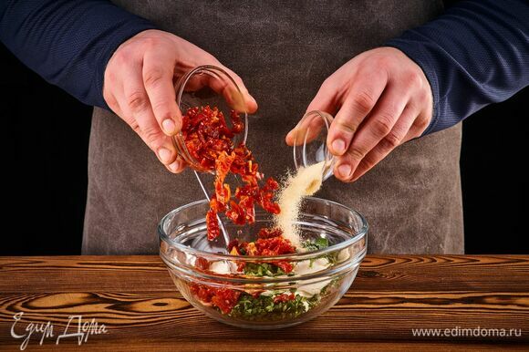 Добавьте сушеный чеснок, мелко нарезанные вяленые томаты и рубленый базилик. Перемешайте.