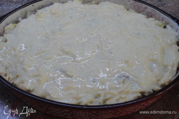 Накройте все оставшейся капустой. Для заливки смешайте яйца со сметаной и тертым сыром. Залейте содержимое формы. Готовьте запеканку в нагретой до 200°C 15–20 минут.