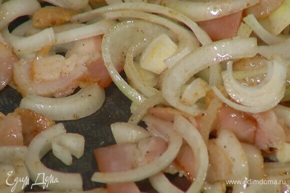 Переложить курицу на тарелку, а в сковороду влить оставшееся оливковое масло и обжарить бекон с луком и чесноком.