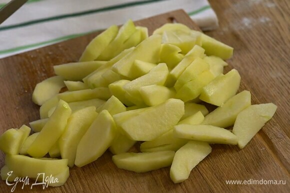 Яблоки почистить и, удалив сердцевину, нарезать дольками, затем сбрызнуть лимонным соком и выложить большую часть в тесто. Все перемешать.